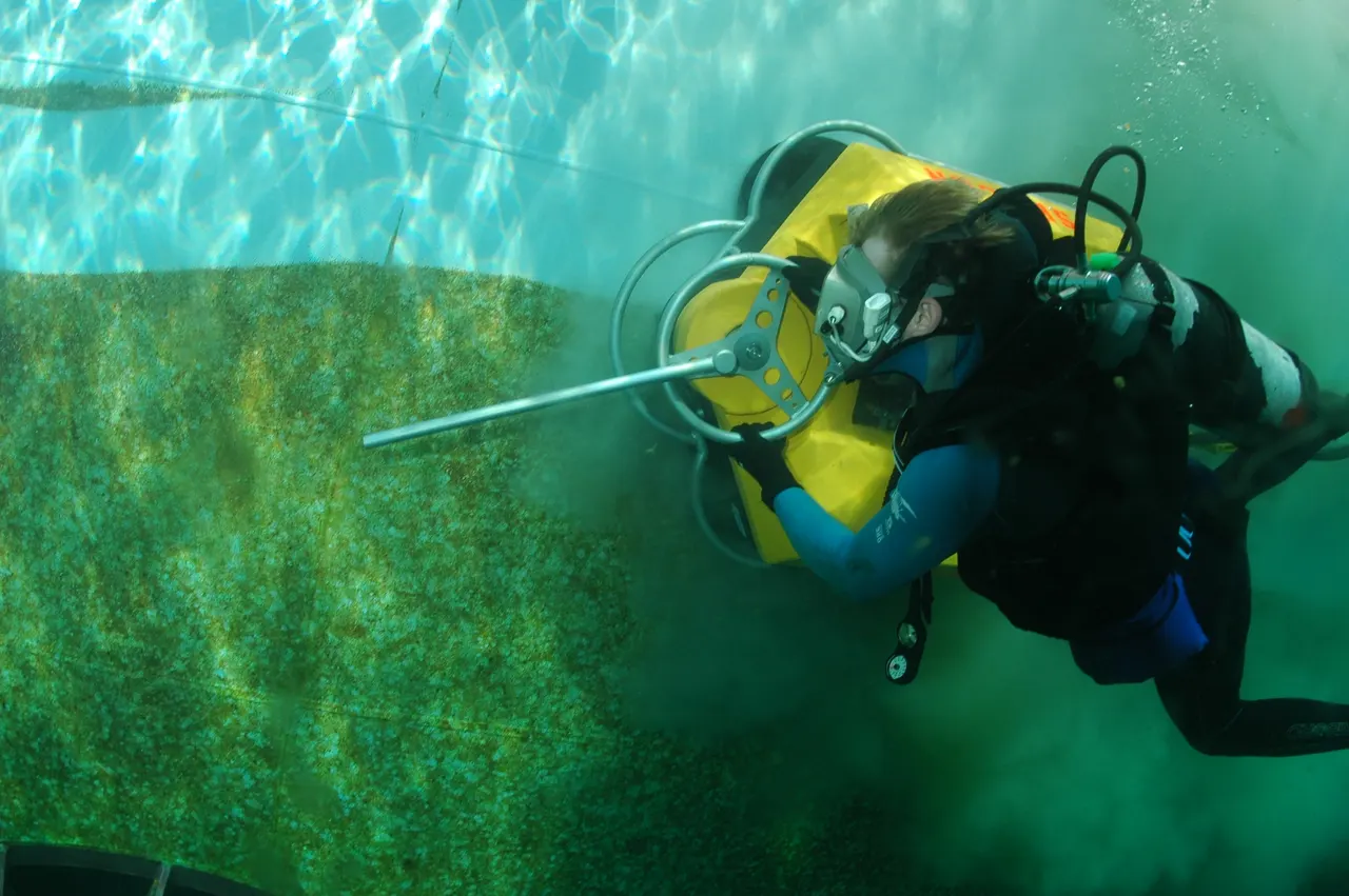 Technical diver with twin cylinders and a stage cylinder exploring a reef